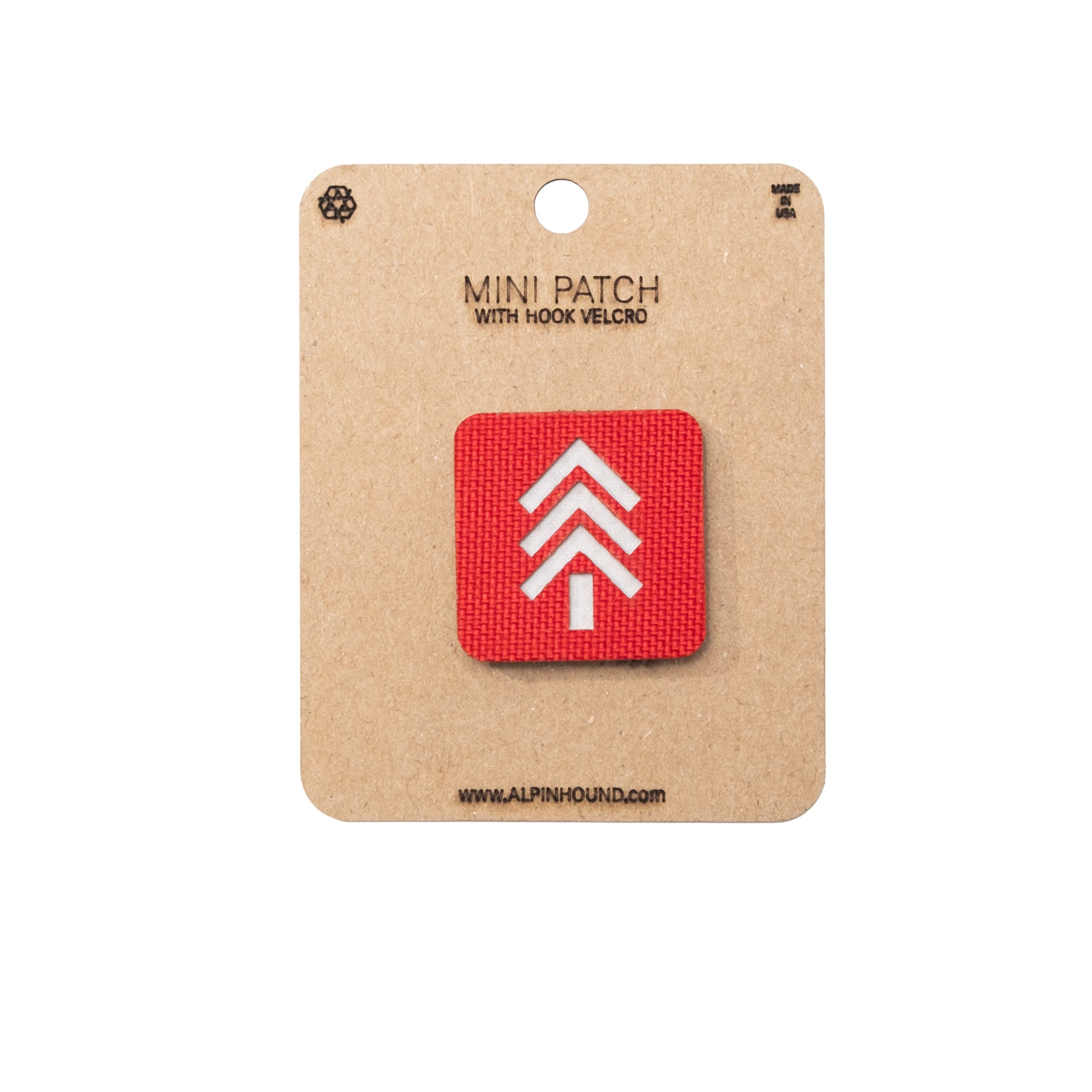 Red square patch with white tree symbol on a cardboard backing