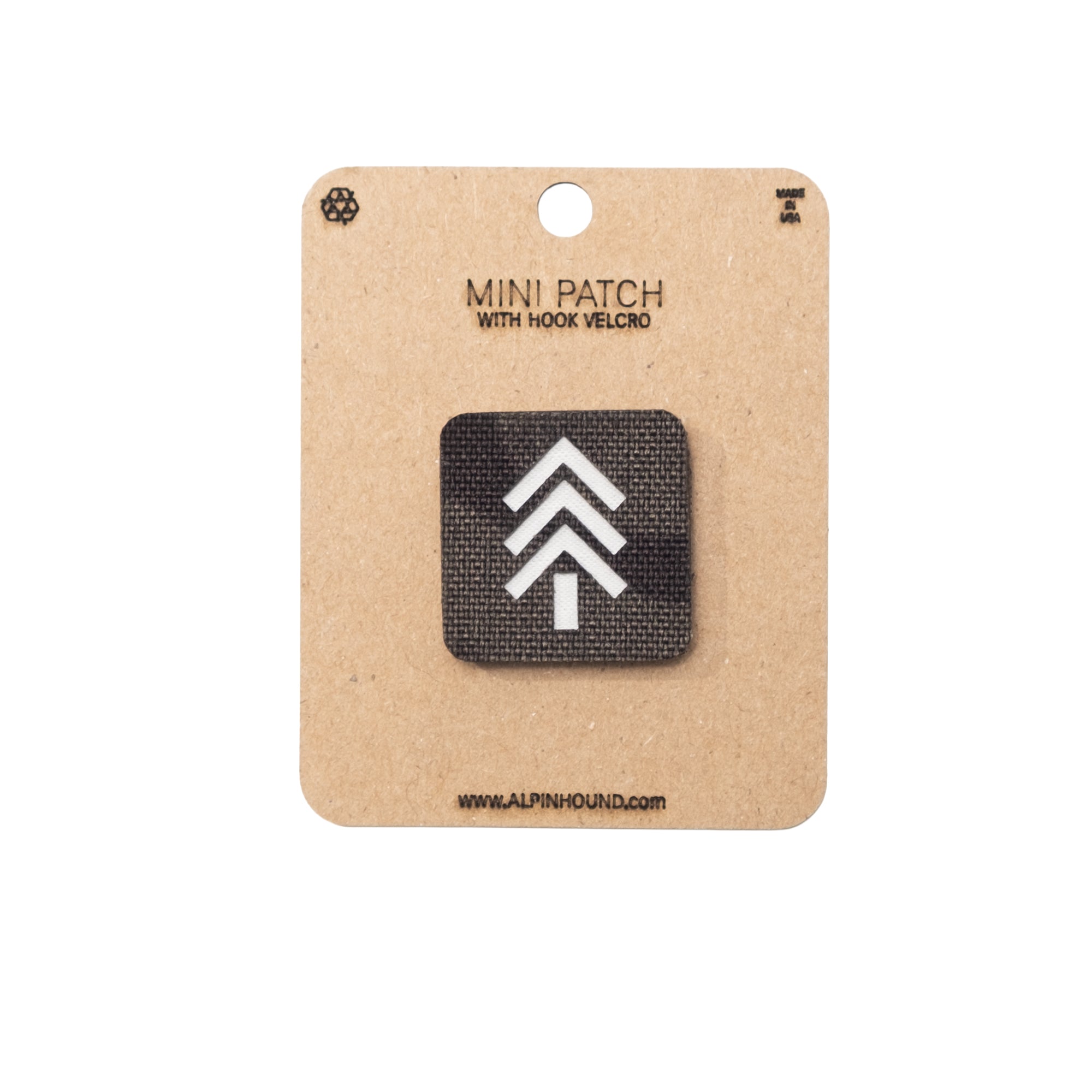 Mini Multicam Black patch with hook and velcro on a cardboard backing, featuring a white logo on a black background.