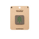 Mini patch with green tree design on a cardboard backing with brand name.