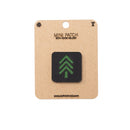 Mini patch with green tree design on a cardboard backing with 'Alpinhound' branding.