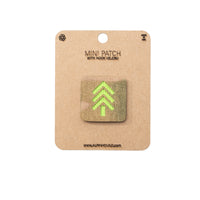 Mini patch with hook and velcro on a cardboard backing, featuring a green tree design.