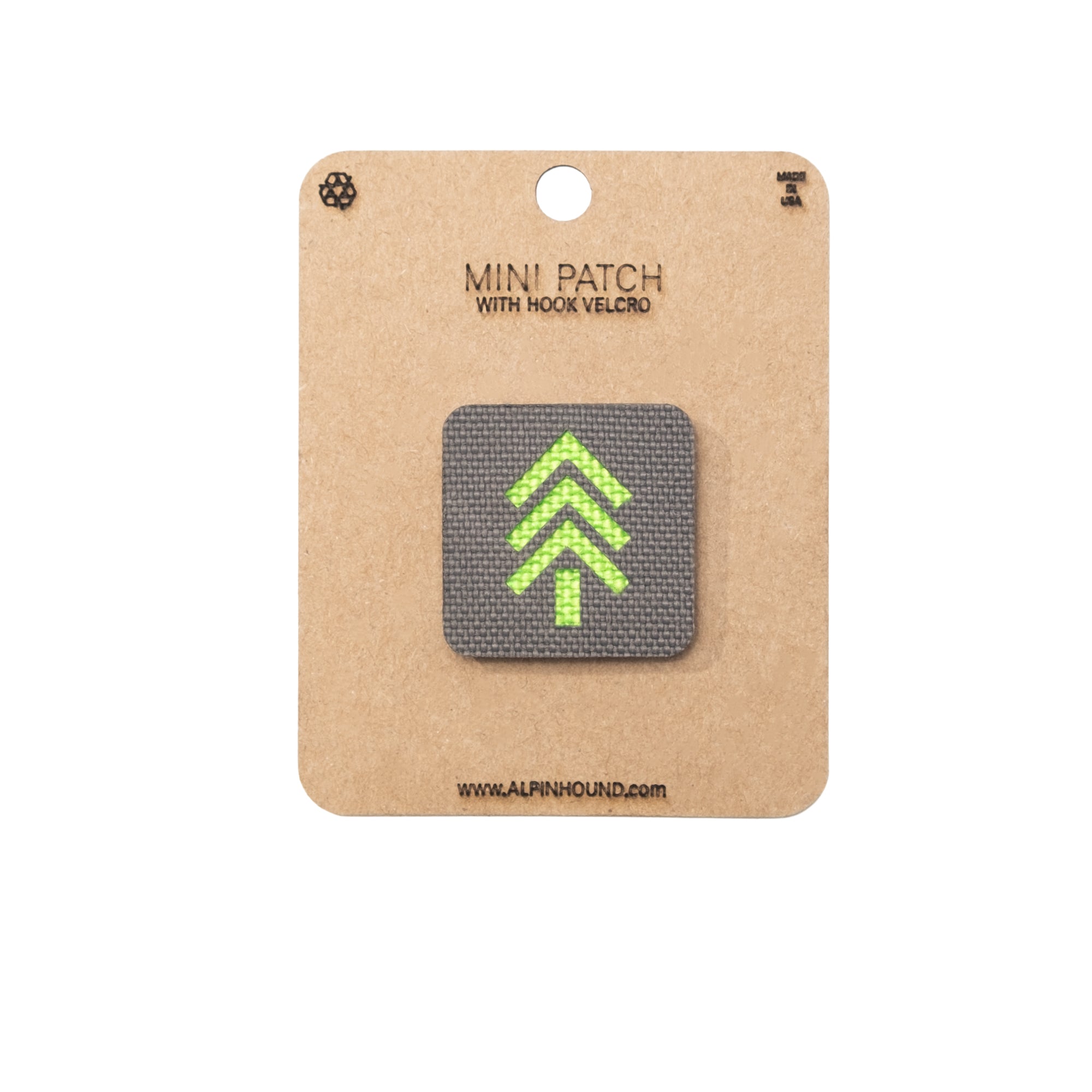 Mini patch with green arrow design on a cardboard backing with &#39;The Alpinhound&#39; branding.